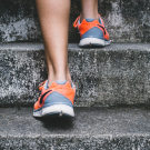pair of feet in sneakers walking up stairs