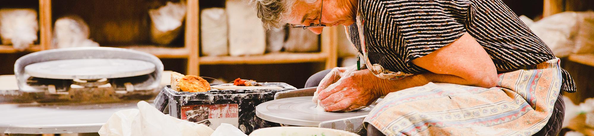 older woman using a potters wheel uc davis craft center